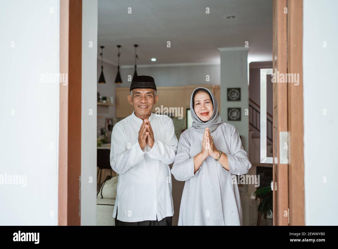 Portrait eines muslimischen asiatischen älteren Ehepaares, das vor der Haustür steht Warten auf Familie zu kommen Stockfoto