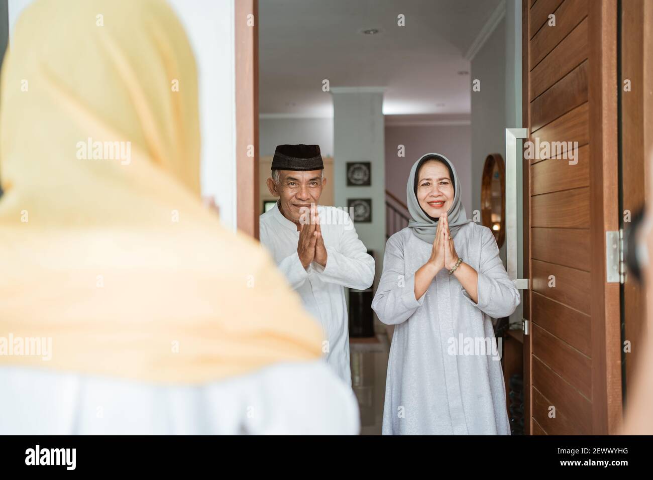 Portrait eines muslimischen asiatischen älteren Ehepaares, das vor der Haustür steht Warten auf Familie zu kommen Stockfoto
