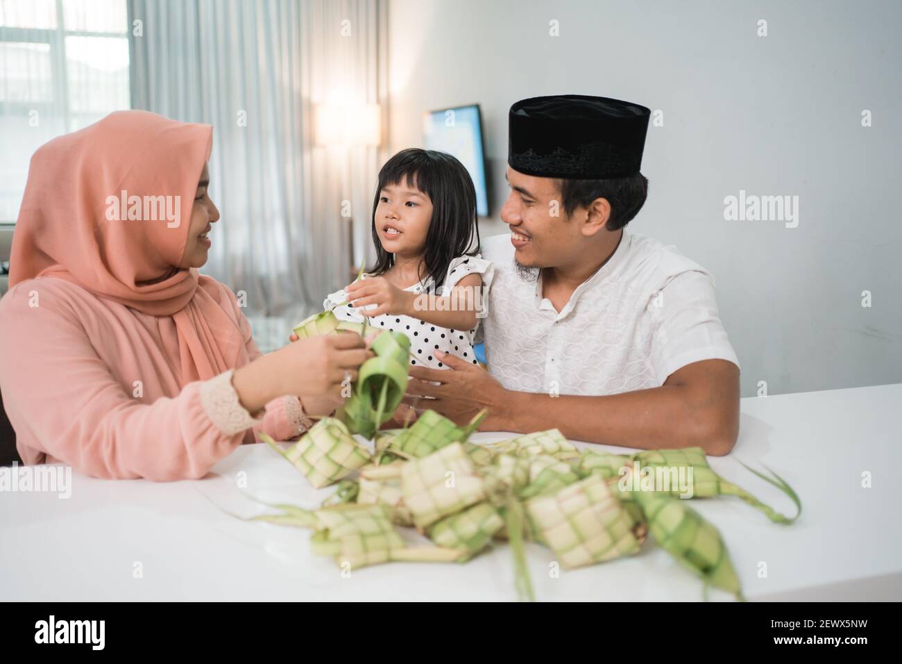 Glücklich asiatische muslimische Familie machen Ketupat zusammen zu Hause vor eid mubarak Stockfoto