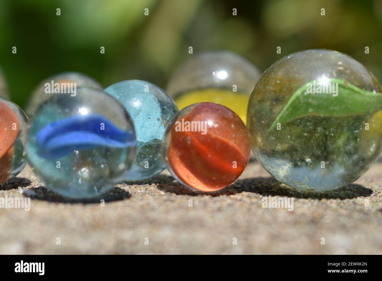 Bunt Spielende Glaskugeln. Glaskugel blau. Abstraktes Foto mit Marmorkugel und Spiegelung. Selektiver Fokus Stockfoto
