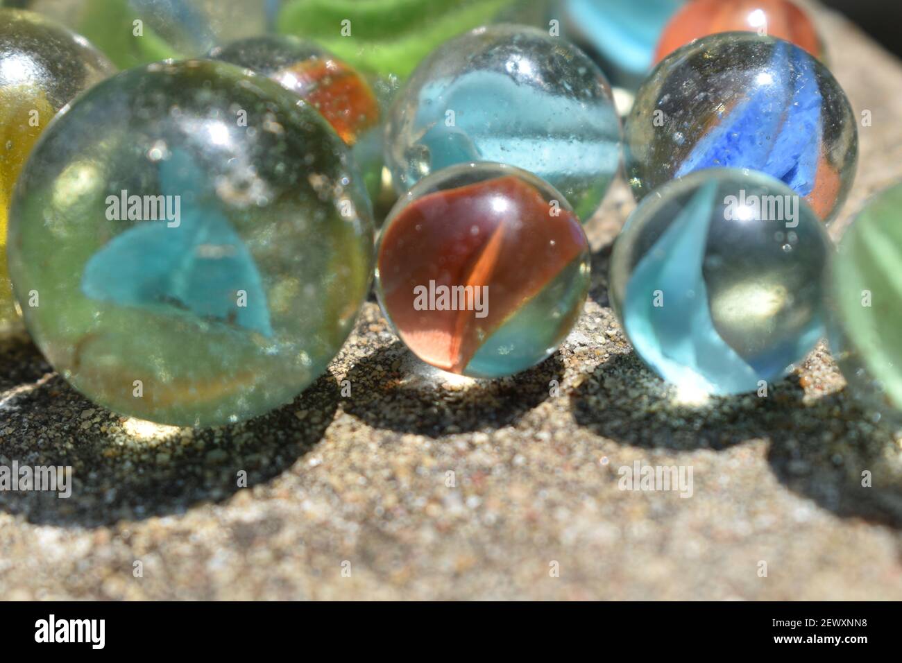 Bunt Spielende Glaskugeln. Glaskugel blau. Abstraktes Foto mit Marmorkugel und Spiegelung. Selektiver Fokus Stockfoto
