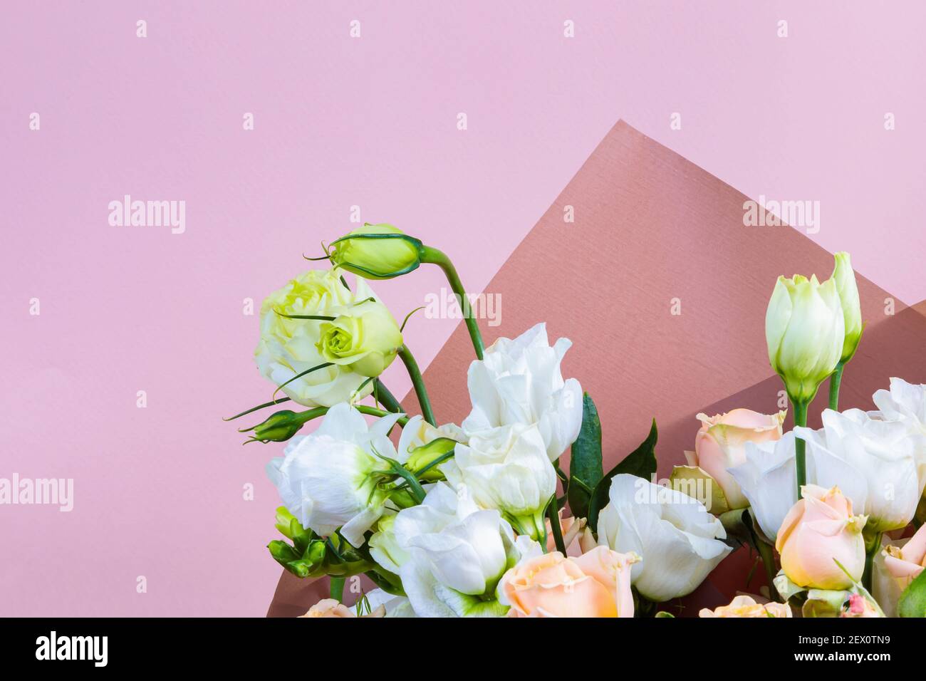 Frisches Bouquet in Pastelltönen von rosa, weiß, grün, gelb. Homogener rosa, blauer Hintergrund. Zartes Bouquet für eine Frau. Stockfoto