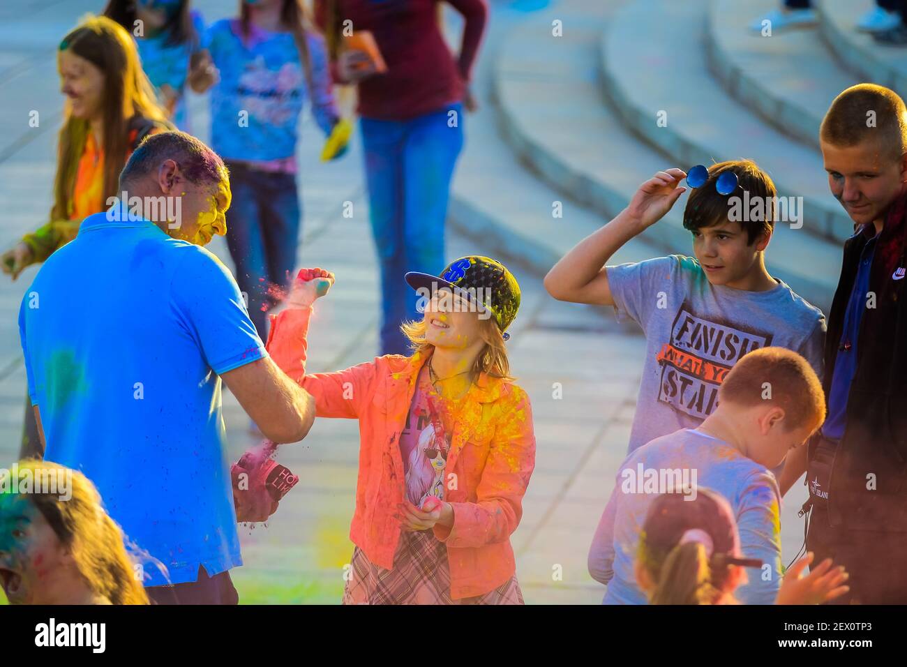 Russland, Moskau - 25. Juni 2017. Fröhliche, junge Menschen werfen sich helle Farben. Fröhliche Gesichter von Erwachsenen und Kindern sind mit Farbe befleckt. Holi Stockfoto