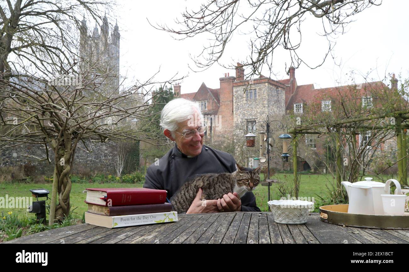 Der Dekan von Canterbury, Reverend Dr. Robert Willis mit Domkatze Tiger, einer von drei schelmischen Katzen, die auf dem 1.400 Jahre alten Sitz der Anbetung in Kent leben, der seine Videogebete ständig stört und zu einem Social-Media-Hit geworden ist. Bilddatum: Dienstag, 2. März 2021. Stockfoto
