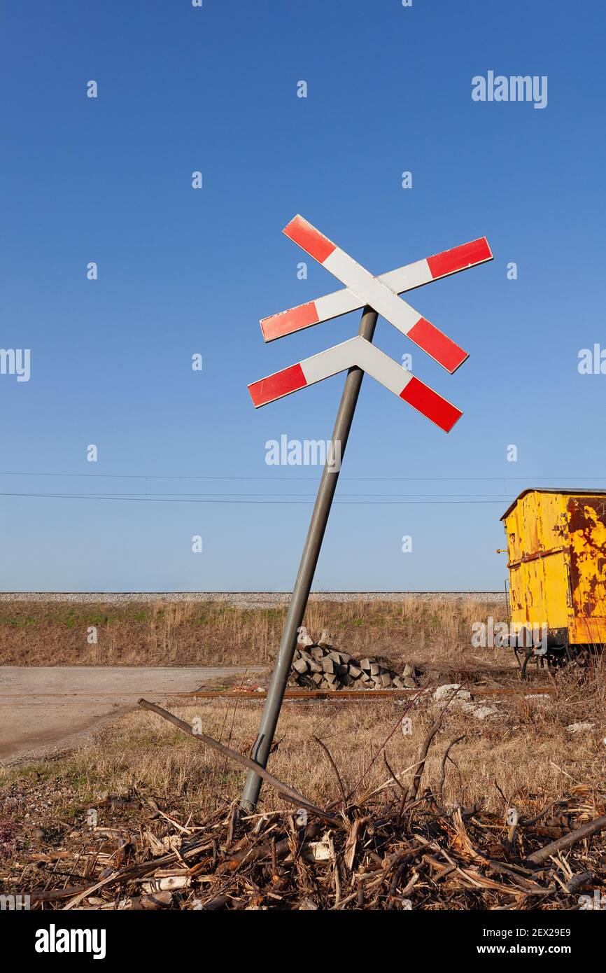St. Andrews Kreuz mit verlassenen gelben Zug Wagen in der Ferne auf einem alten Gleis Stockfoto