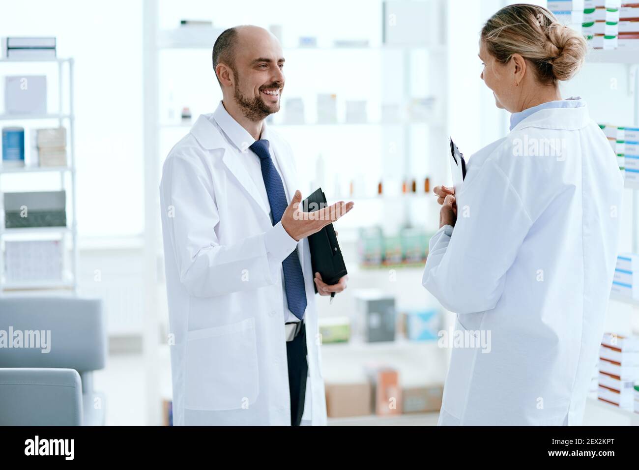 Leitende Apothekerin diskutiert etwas mit ihrem Kollegen. Stockfoto