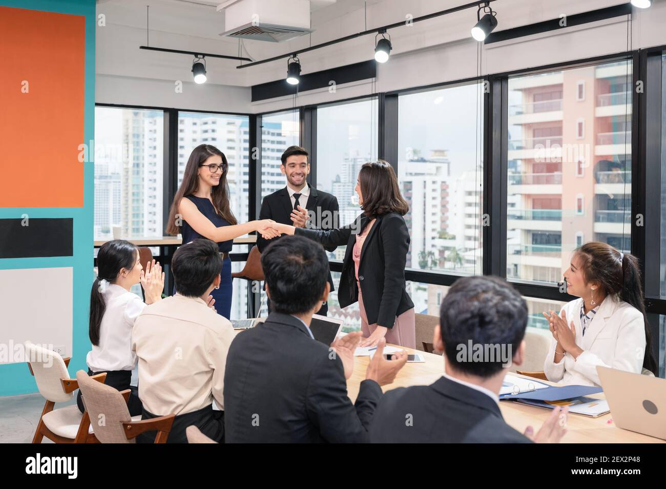 Multi ethnische Geschäftsfrau schüttelt Hände Zusammenarbeit für Corporate Agreement mit Mitarbeiter im modernen Büro Stockfoto