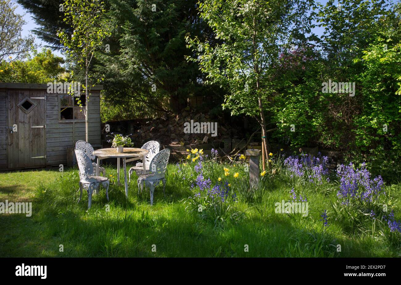 Sitzmöbel mit Metallbesiderungen im wilden Bereich des englischen Gartens Stockfoto