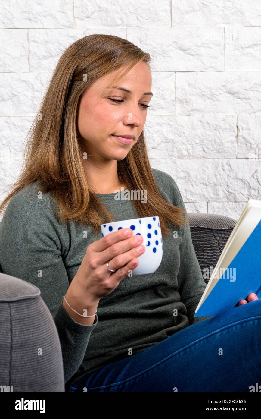 Mädchen hält eine Tasse mit Punkten, während sie lächelt Buchen Stockfoto