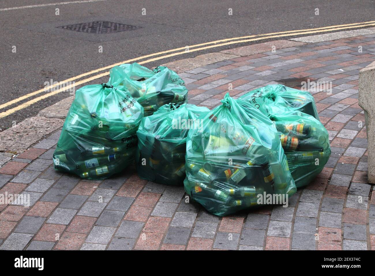 LONDON, Großbritannien - 14. JULI 2019: Grüne Tüten mit Glasflaschen warten auf Müllabfuhr in London. London ist die bevölkerungsreichste Stadt und Metropolregion i Stockfoto