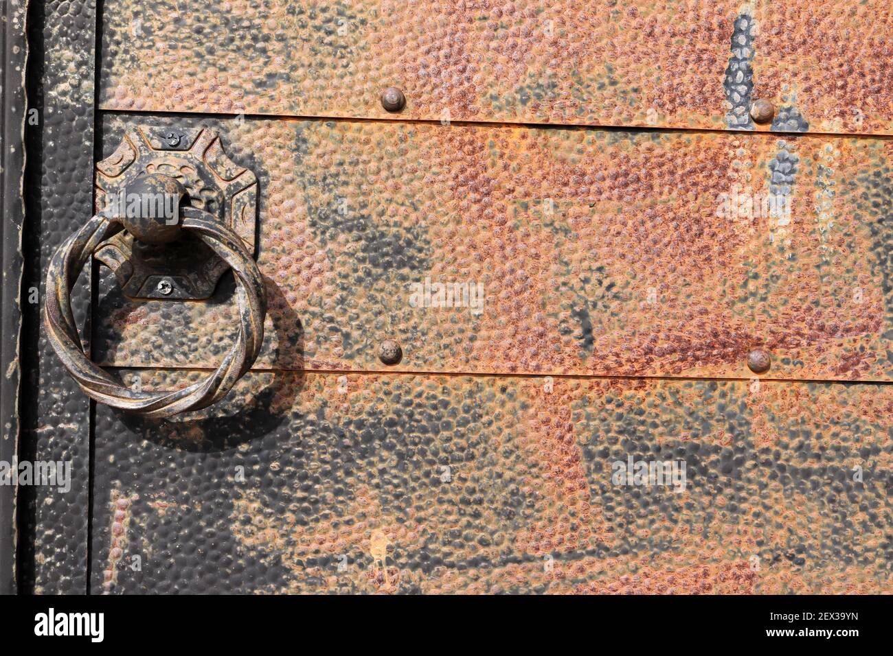 Alte genietete Eisentür.Metallgriffe. Stockfoto