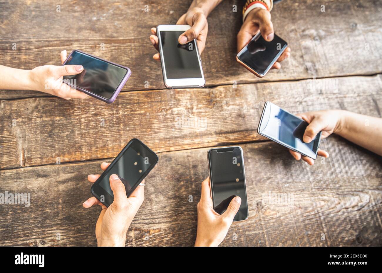 Mitarbeiter mit Handy auf Holzhintergrund - Nahaufnahme von Personen, die Inhalte in sozialen Medien teilen Mit Smartphone Stockfoto