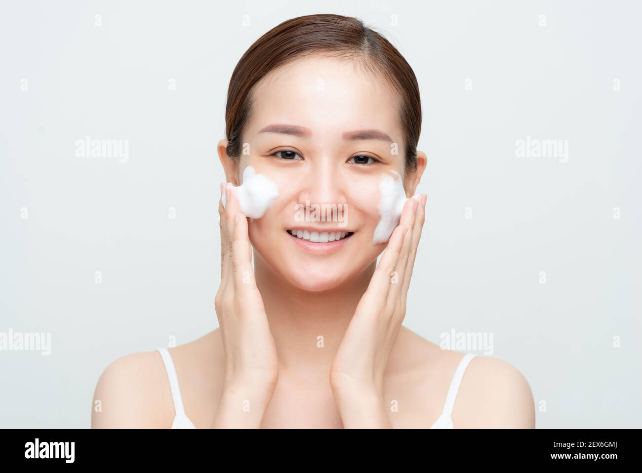 Attraktive Schönheit junge asiatische Frau Waschen bis ihr Gesicht mit Schaumreiniger in den Morgen. Stockfoto
