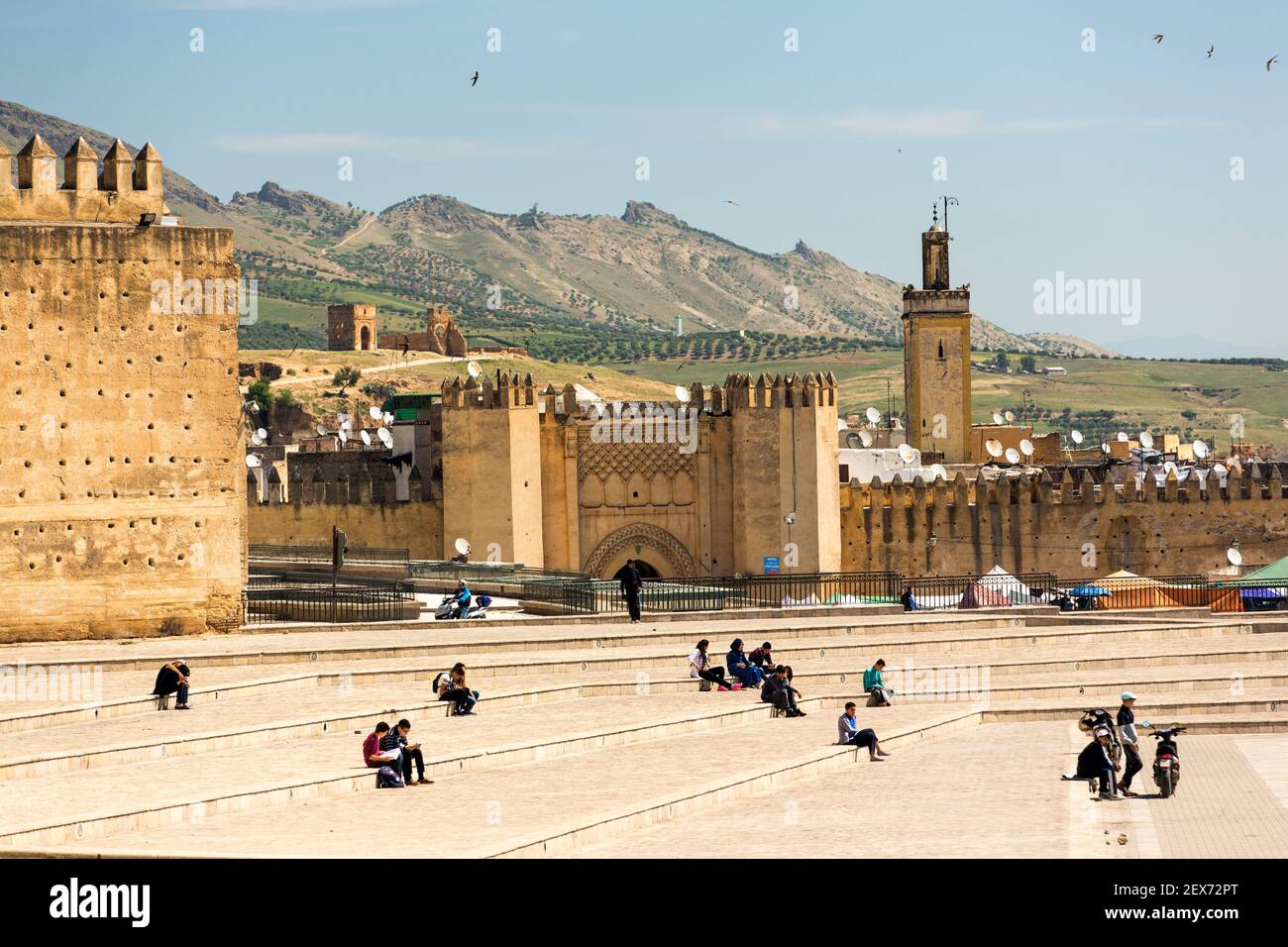 Marokko, Fes, Stadtmauern oder mechouar, die die im 17. Jahrhundert erbaute Stadt umgeben, mit Menschen, die auf einem offenen Platz sitzen Stockfoto