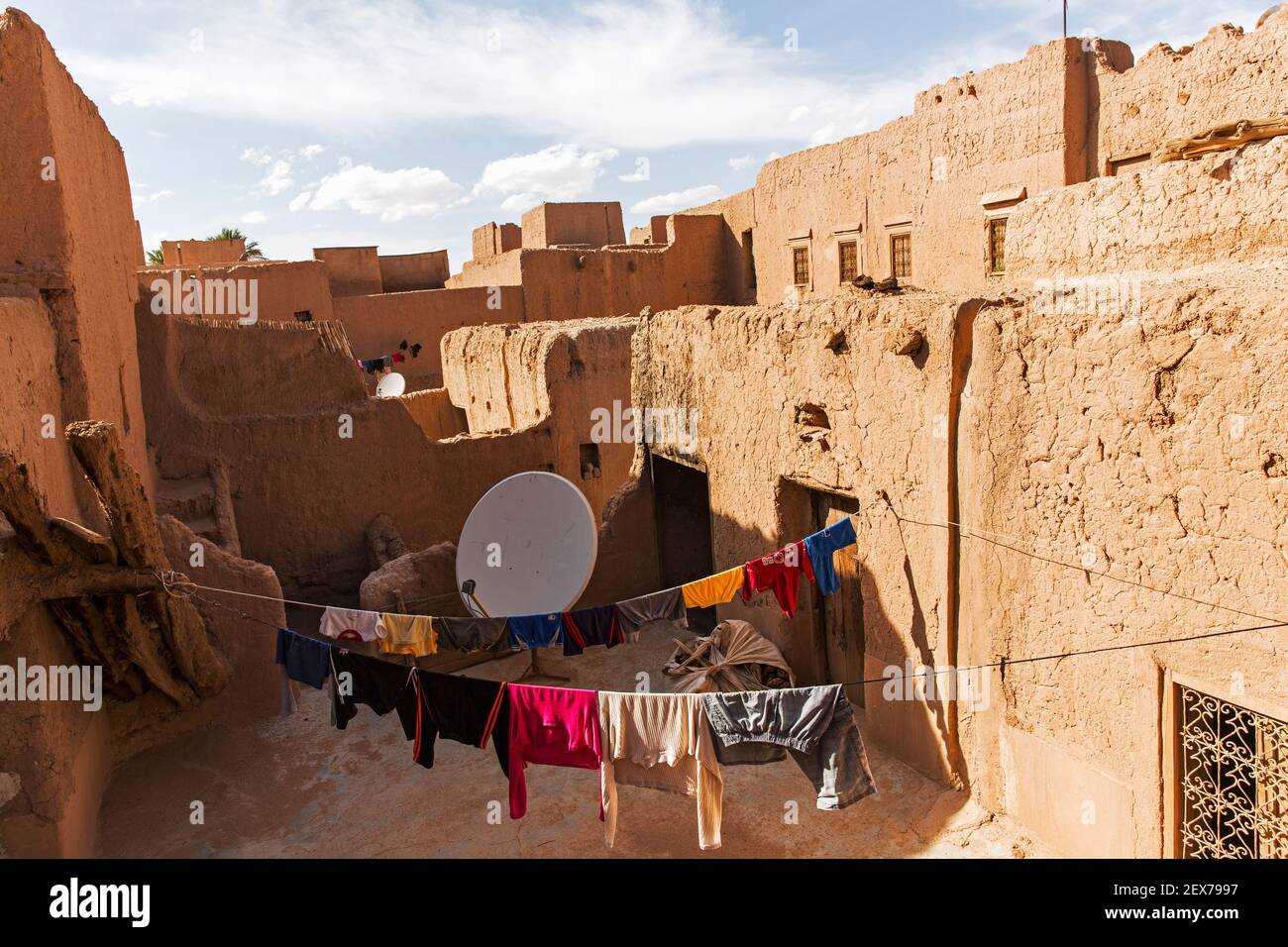 Marokko, Tinejdad, Todra-Tal, Ksar El Khorbat, ist ein Dorf von befestigten Mauern aus Erde, mit Satellitenschüssel und hängende Wäsche Stockfoto