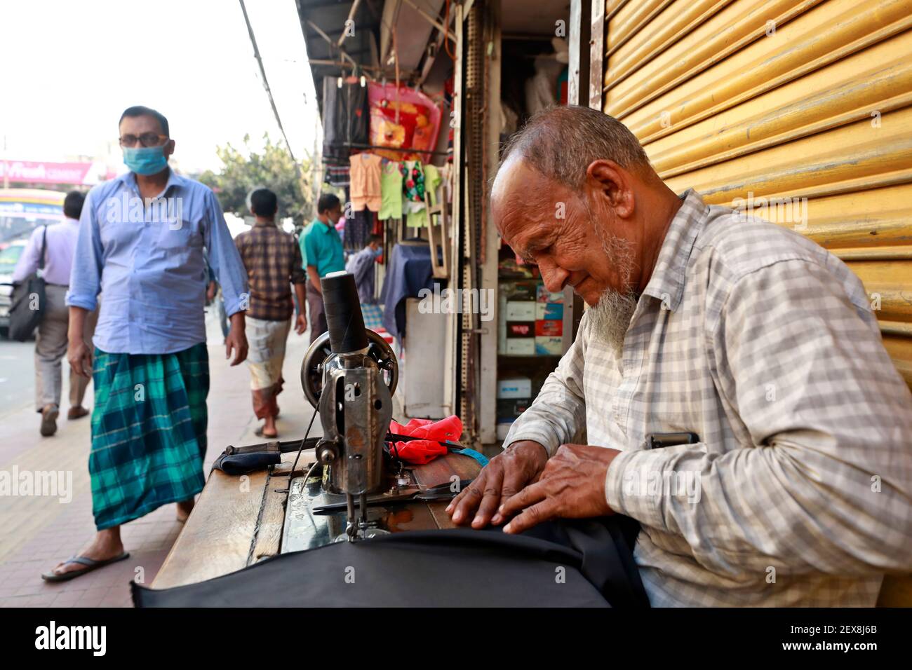 Dhaka, Bangladesch - 04. März 2021: Md. Sultan näht seit 30 Jahren auf dem Bürgersteig von Badda in Dhaka. Aber jetzt ist sein Einkommen nicht das gleiche wie b Stockfoto