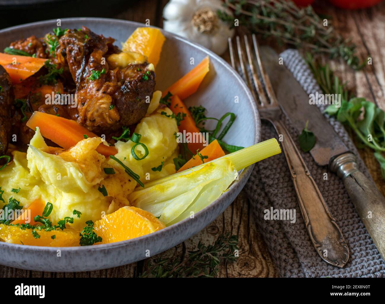 Köstliche Gemüsebeilage mit, Fenchel, Karotten in Orangensaft gekocht und serviert mit Orangen und Kartoffelpüree auf einem Teller mit Fleisch Stockfoto