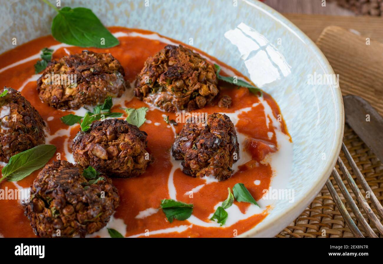 Veganes Fleischgericht mit Linsennussfleischbällchen und Tomatensauce Serviert auf einem Teller Stockfoto
