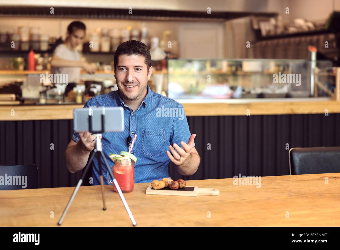 Social-Media-Influencer oder Food-Blogger erstellen digitale Marketing-Inhalte Durch Filmen von Videos im Restaurant für kleine Unternehmen Stockfoto