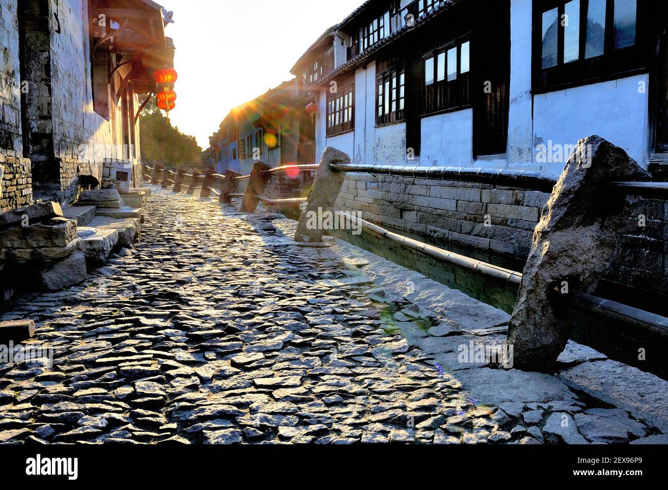 Morgenlicht in Zhou Zhuang mit Kopfsteinpflasterstraße und Hintergrundbeleuchtung Stockfoto