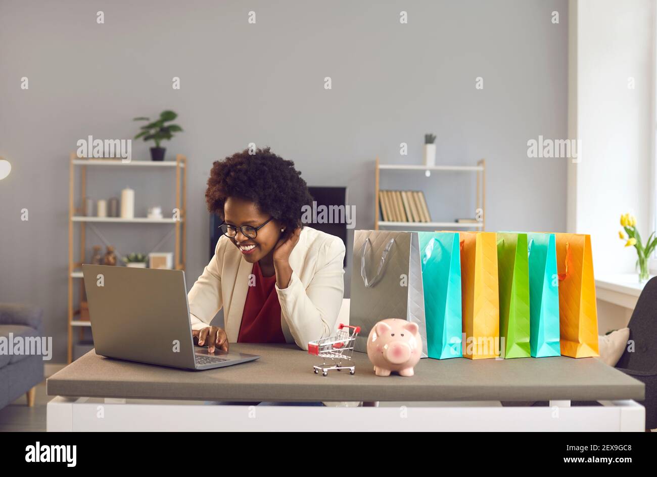 Inspirierte afroamerikanische Frau Kauf online treffen Entscheidungen auf Laptop Stockfoto