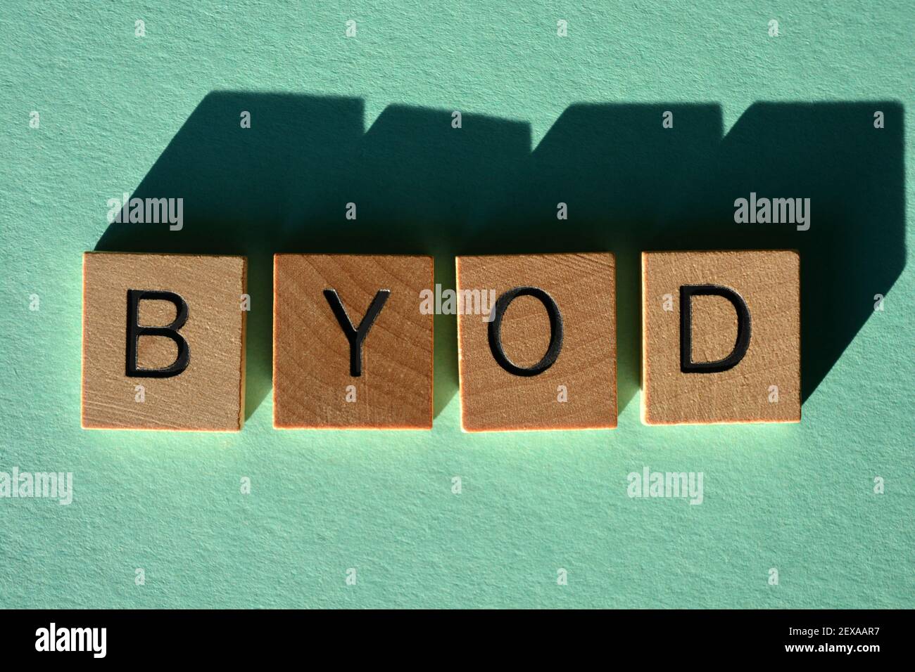 BYOD, Akronym für Bring Your Own Device in Holzbuchstaben isoliert auf grünem Hintergrund Stockfoto