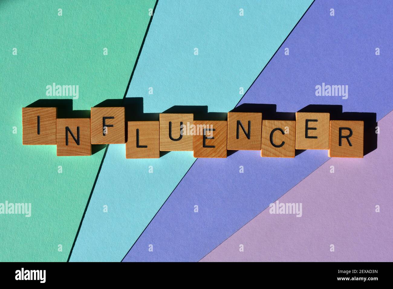 Influencer, Wort in hölzernen Buchstaben auf buntem Hintergrund isoliert. Stockfoto
