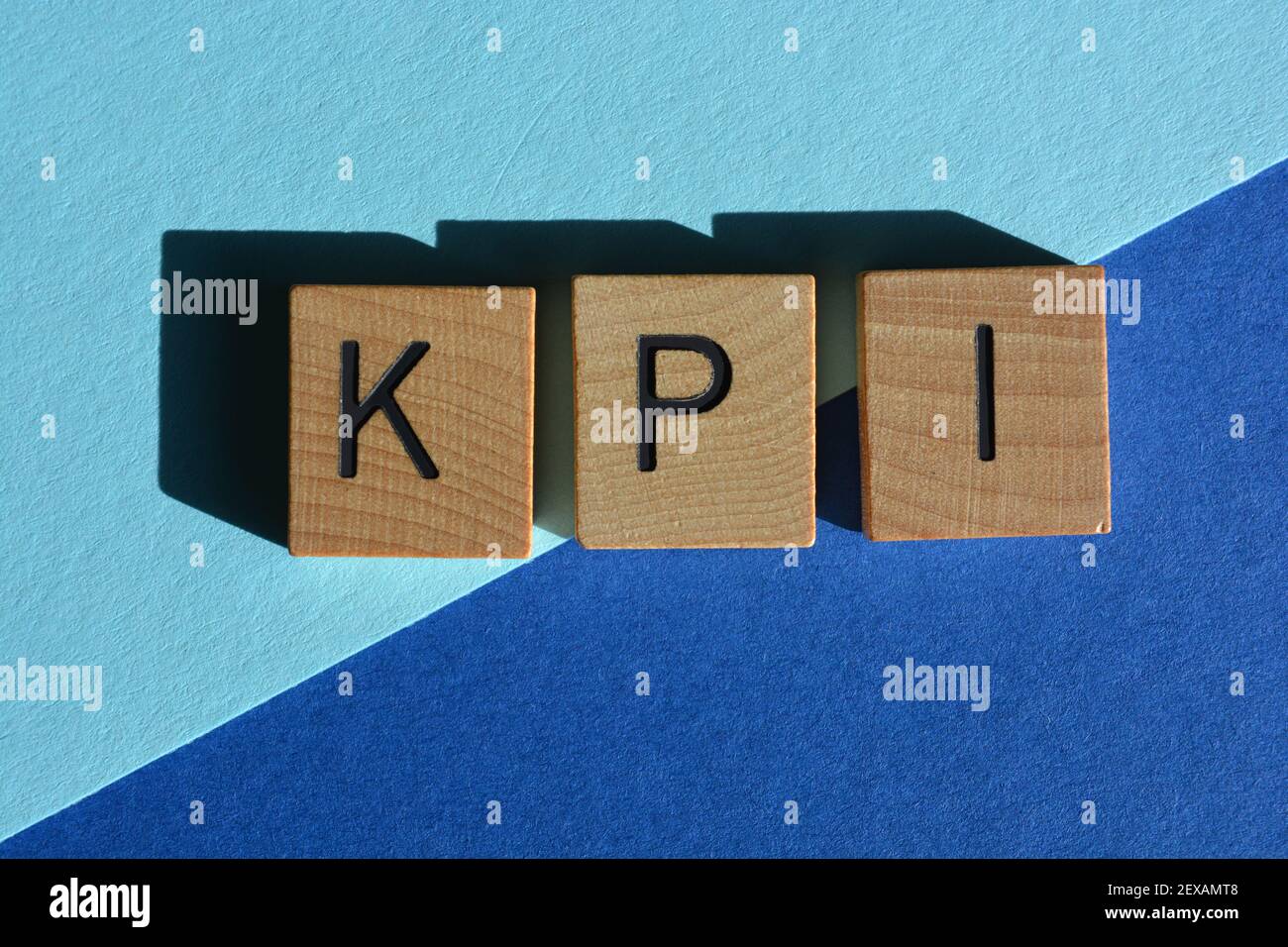 KPI-Technologie Akronym für Key Performance Indicator in Wooden Alphabet Buchstaben auf blauem Hintergrund isoliert Stockfoto