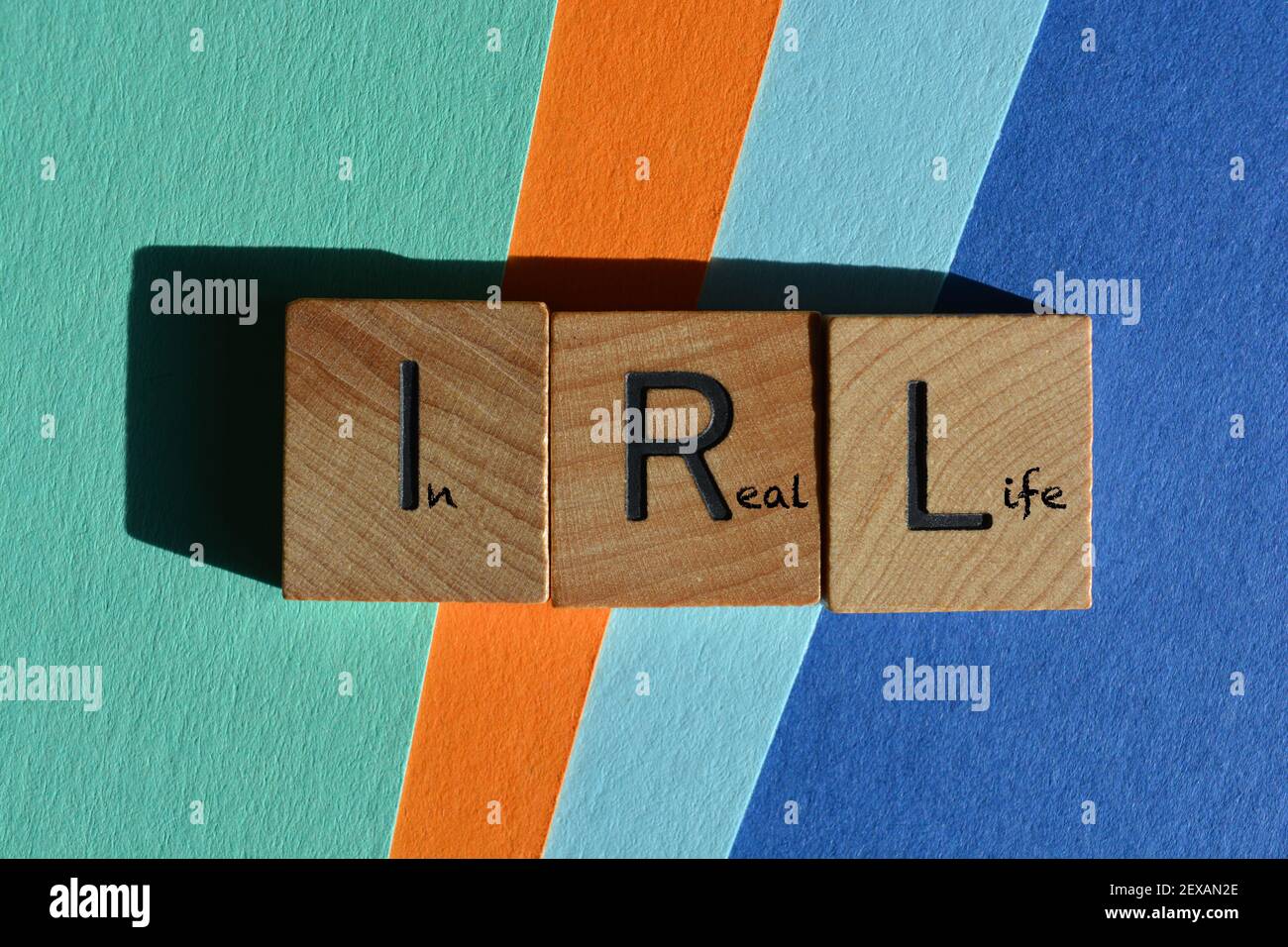 IRL, in Real Life, Akronym und Wörter in hölzernen Buchstaben auf buntem Hintergrund isoliert Stockfoto