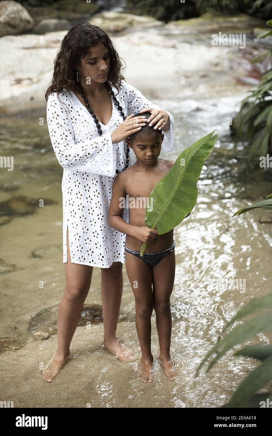 Kleiner Junge und seine Mutter draußen am Fluss, Henri Pittier Nationalpark, Venezuela. Stockfoto