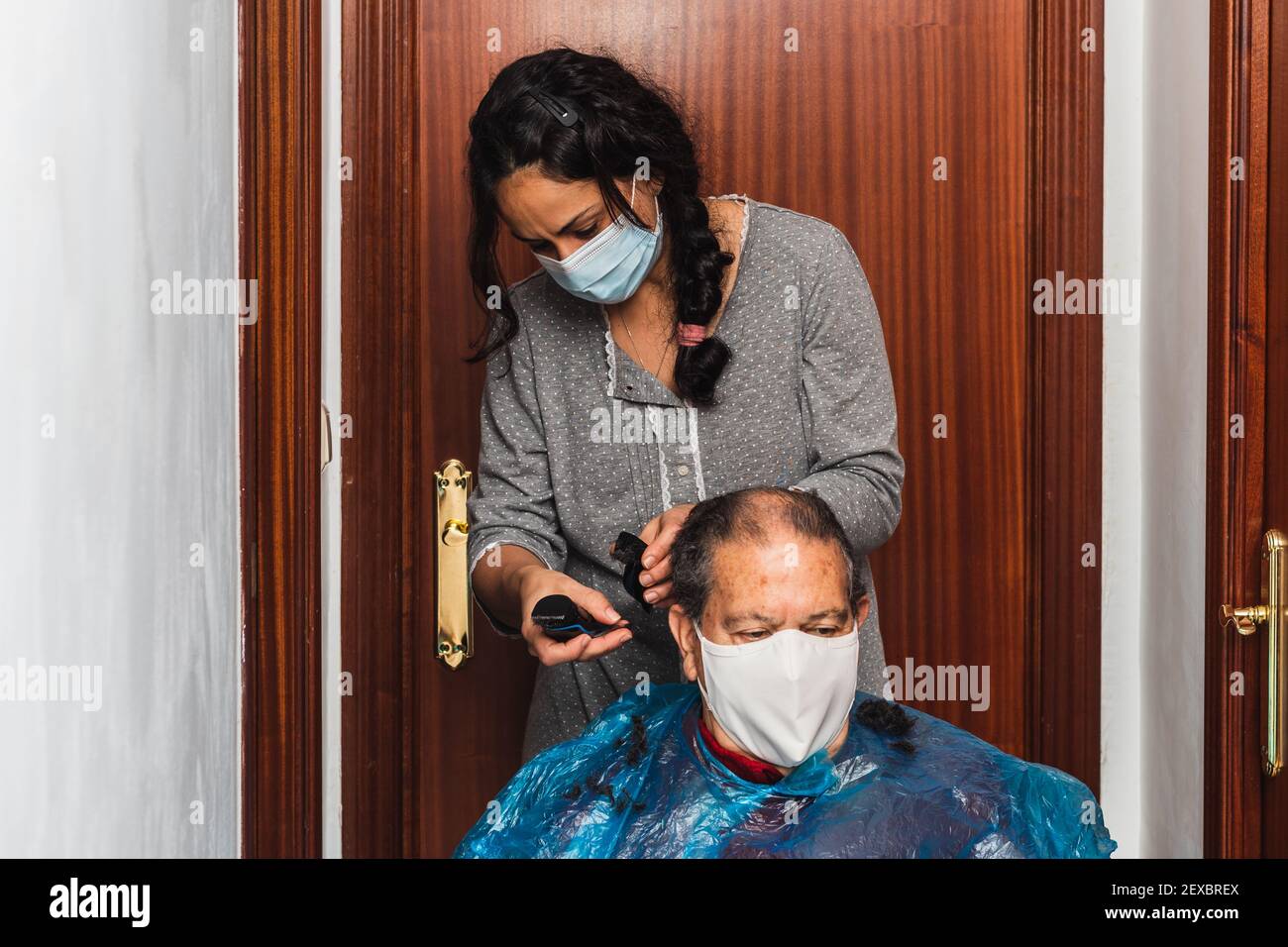 Tochter schneidet ihrem Vater die Haare zu Hause Stockfoto