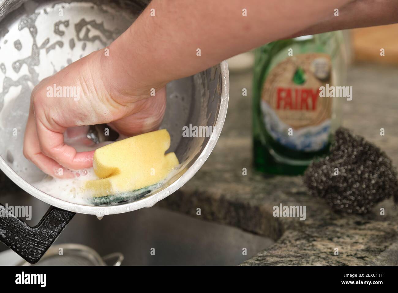 Madrid, Spanien. 4. Januar 2021: Mann Hände waschen einen Topf oder das Geschirr mit Fee. Stockfoto
