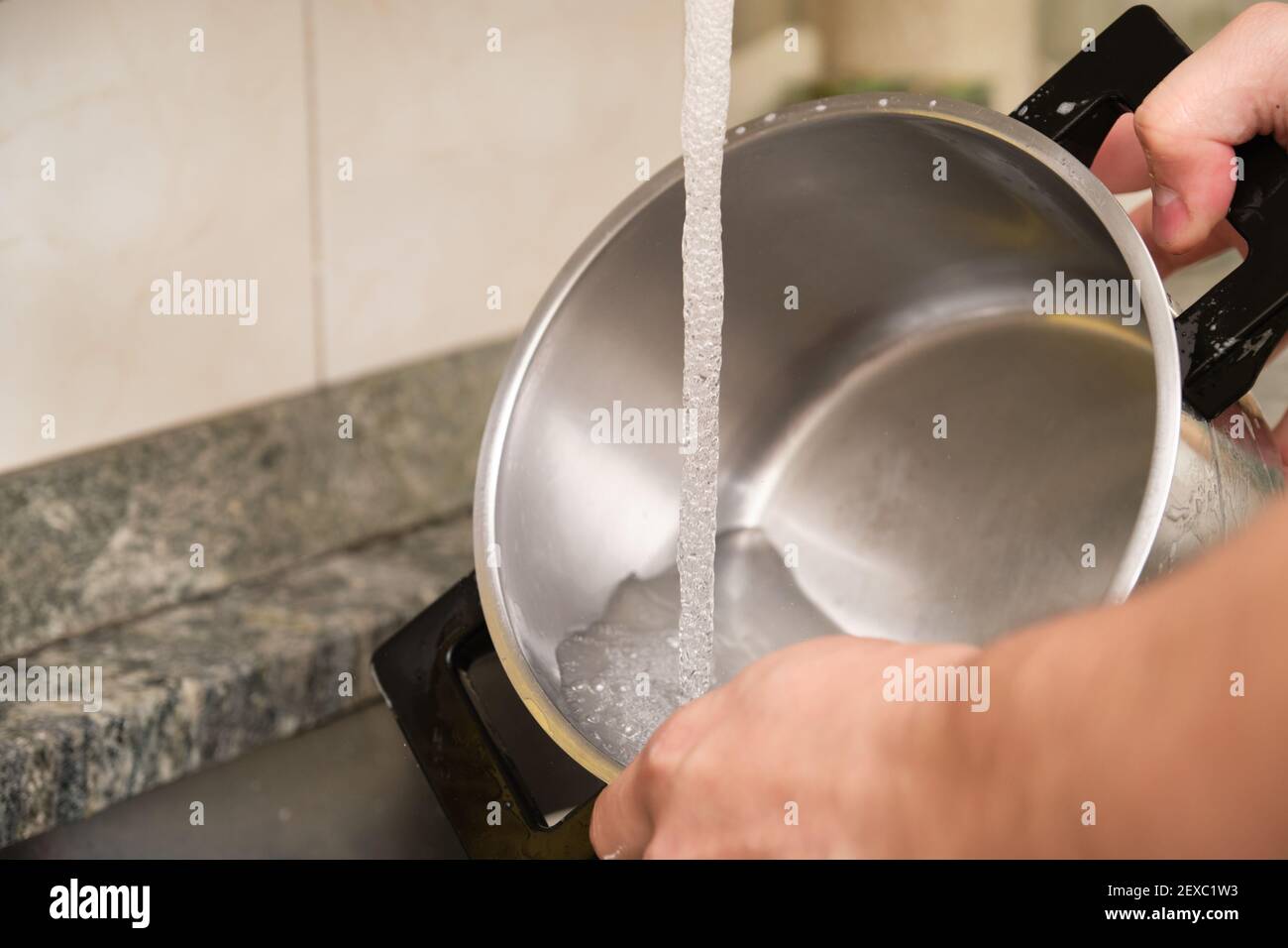 Zugeschnittenes Bild eines Mannes Hände waschen einen Topf oder das Geschirr tun. Reinigung der Hausarbeiten. Stockfoto