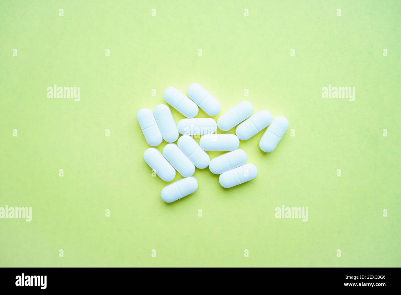 Weiße Pillen auf einem hellgrünen Hintergrund Stockfoto
