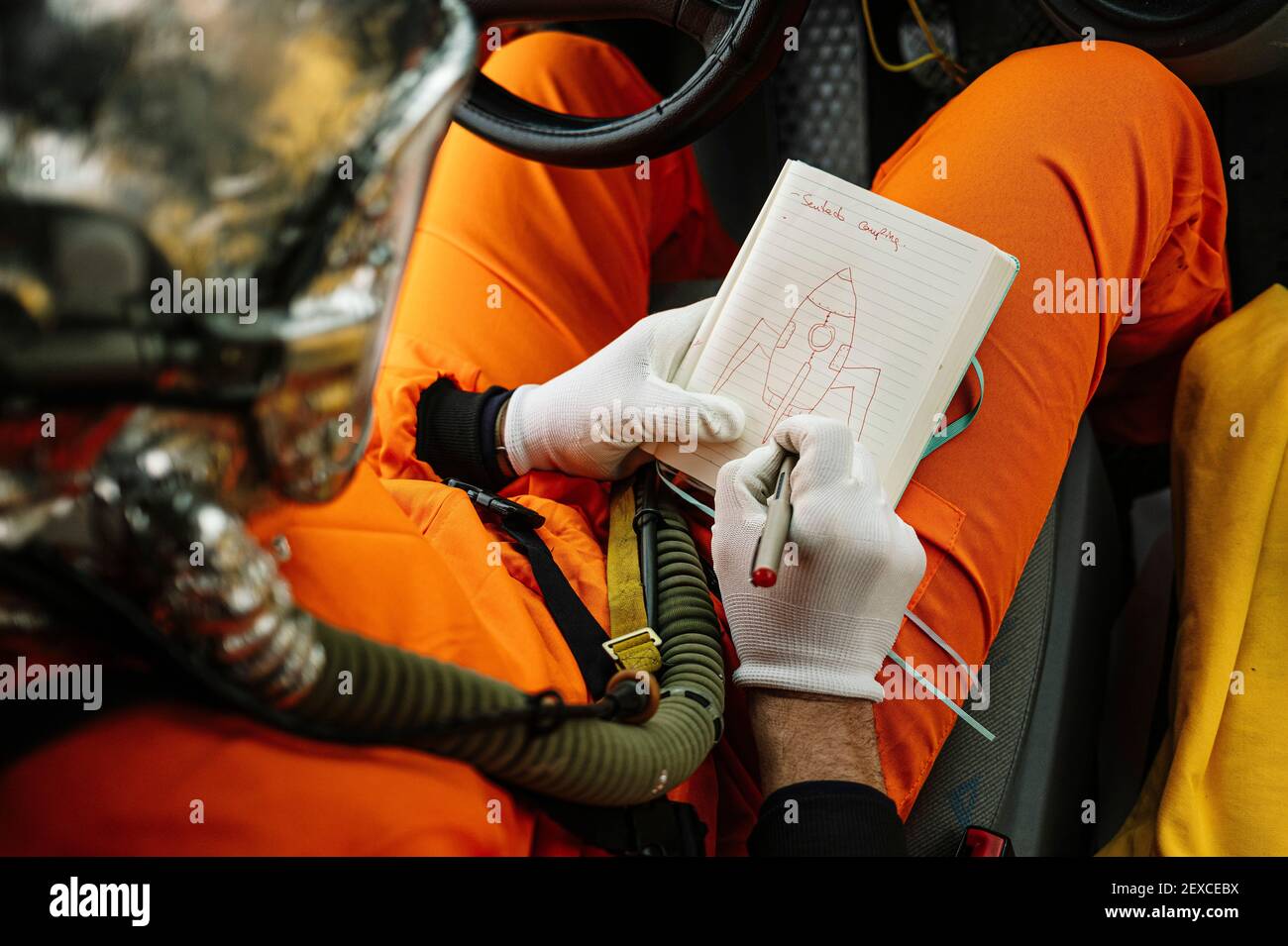Mann als Astronaut gekleidet zieht eine Rakete auf die Notizbuch Stockfoto