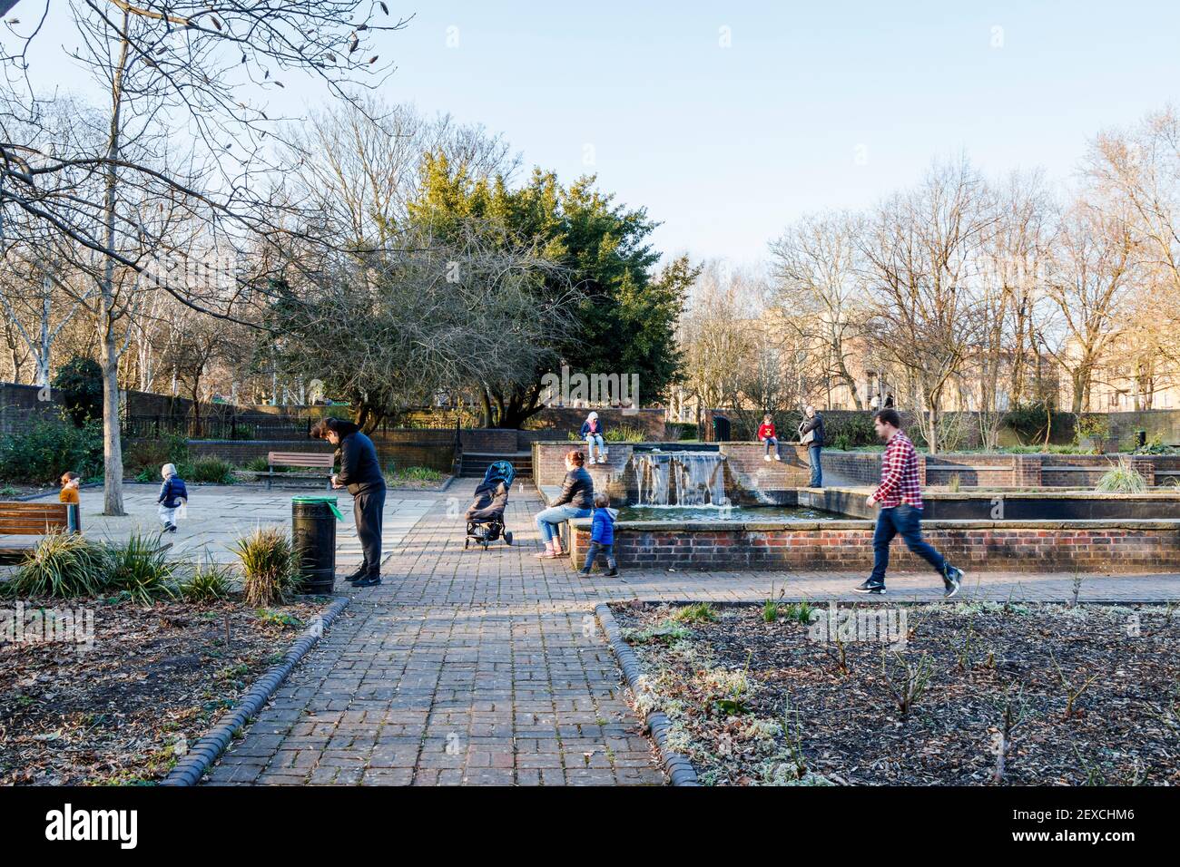 Eltern und Kinder im Peace Garden of Elthorne Park an einem Winternachmittag in Islington, London, Großbritannien Stockfoto