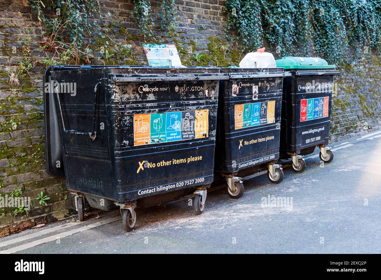 Drei Müllcontainer auf Rädern auf einer wohnanlage in Islington, London, Großbritannien Stockfoto