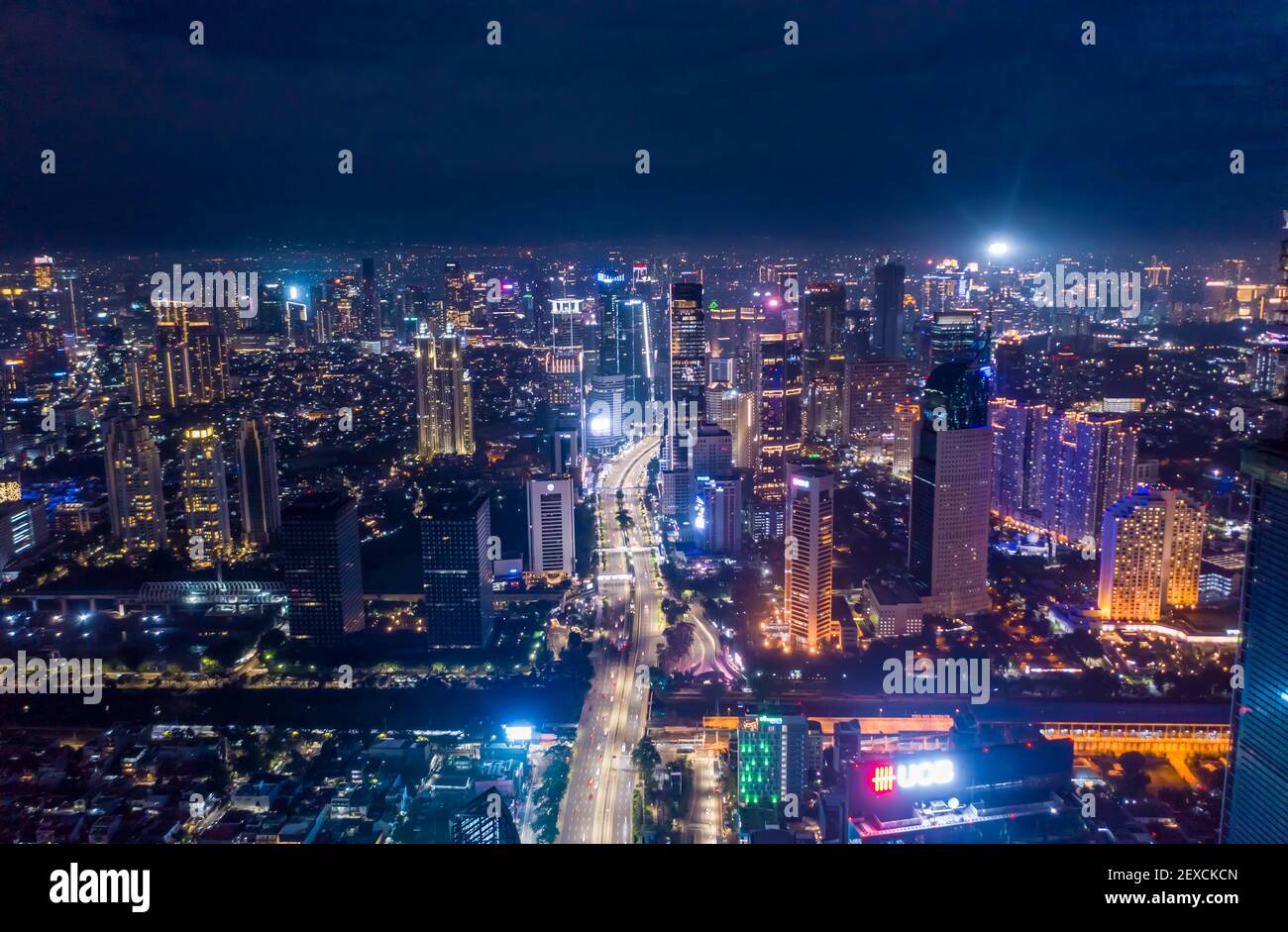 Luftaufnahme Nacht Stadtbild von Wolkenkratzern und mehrspurigen Autobahn-Verkehr im modernen Stadtzentrum von Jakarta, Indonesien Städtisches Stadtzentrum mit Hochhäusern bei Nacht Stockfoto