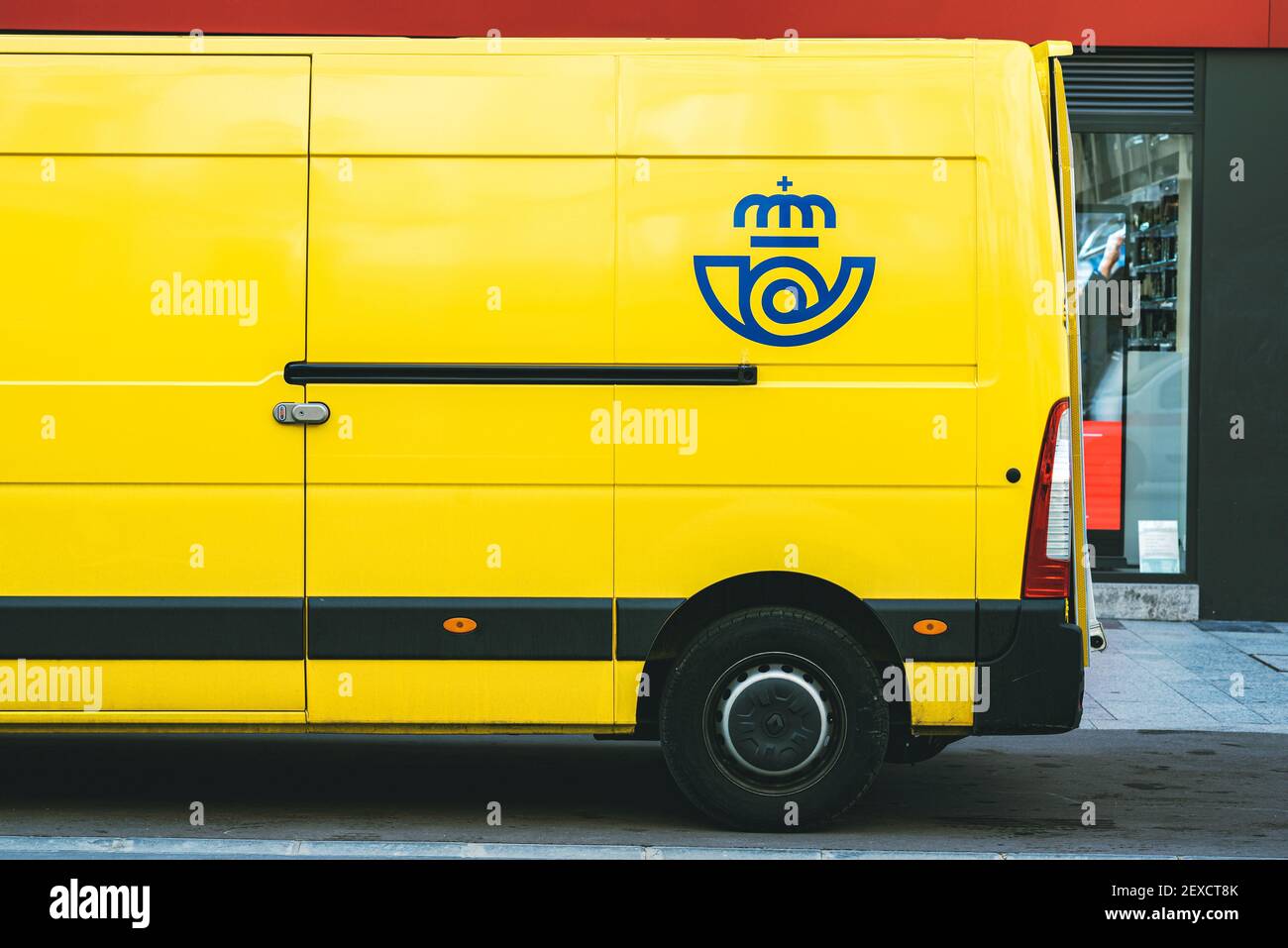 Gelber Lieferwagen von Correos, die Post spanische Postfirma liefert Auf einer öffentlichen Straße.Öffentliche Post in Spanien Stockfoto