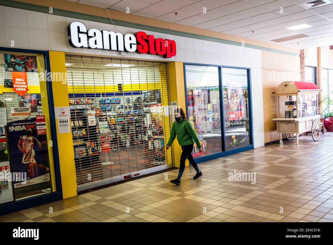 Mall Walkers flanieren an einem geschlossenen und verlassenen Game Stop Store in der Berlin Mall, Berlin, VT, USA vorbei. Stockfoto