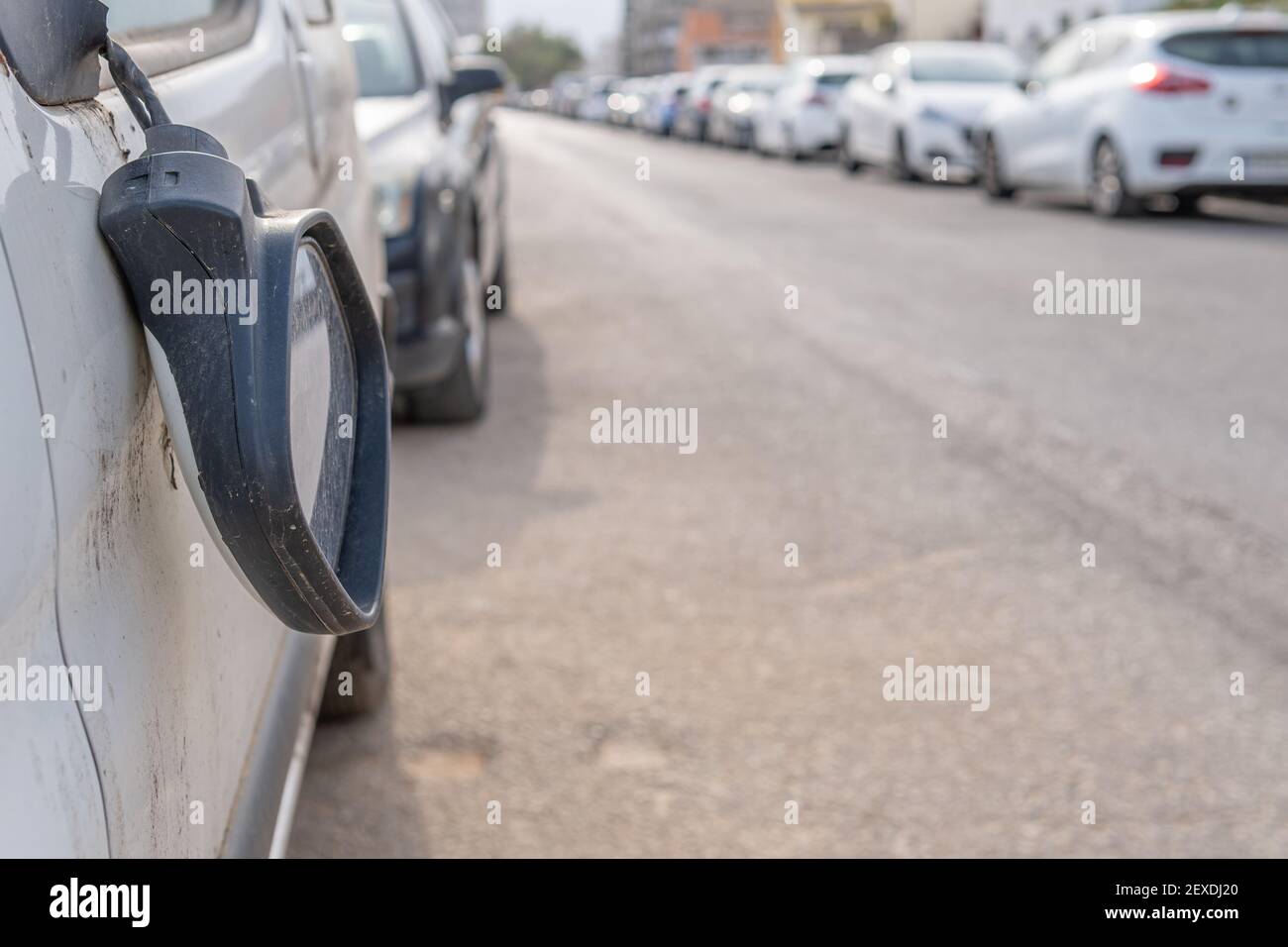 Nahaufnahme eines zerbrochenen Rückspiegels eines weißen Automobils An einer unbestimmten Stadtstraße Stockfoto