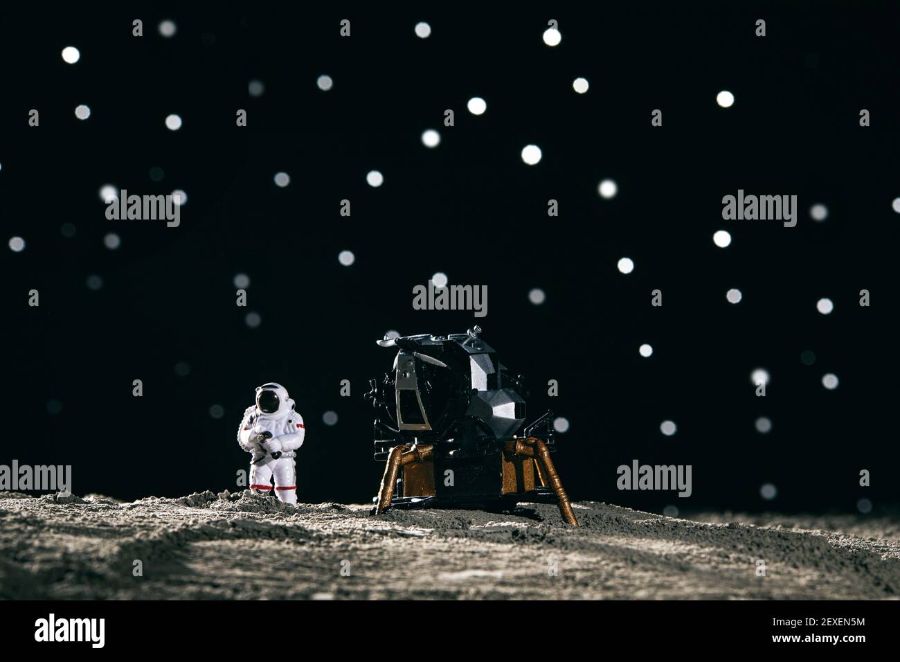 Ein Astronaut Miniaturspielzeug neben einem Raumschiff auf dem mond vor Bokeh Hintergrund Stockfoto