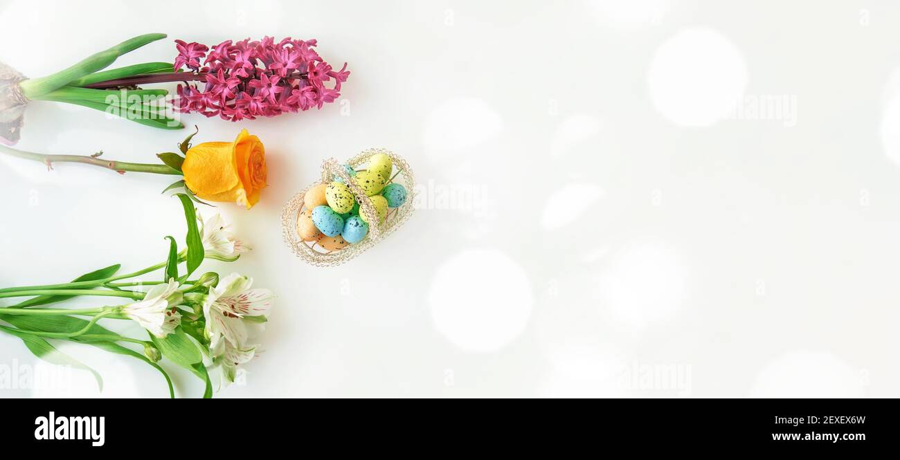 Korb mit dekorativen Eiern und Blumen auf dem Ostertisch. Draufsicht, Banner. Osterdekor, Kopierer. Stockfoto