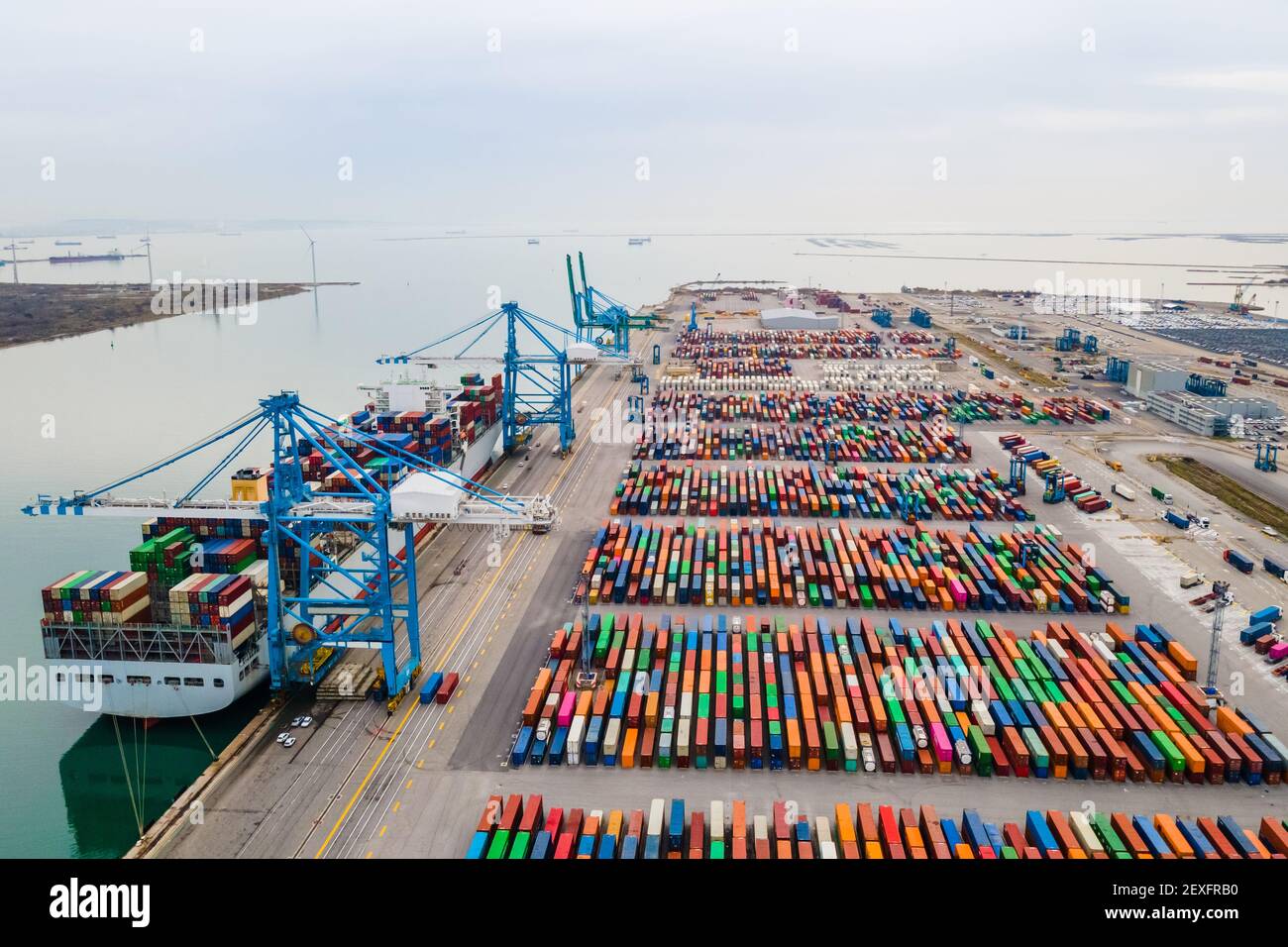 Containerhafen mit großem Schiff, das mit Portalkran beladen und entladen wird. Internationaler Versand und globaler Güterverkehr und Handel. Antenne V Stockfoto