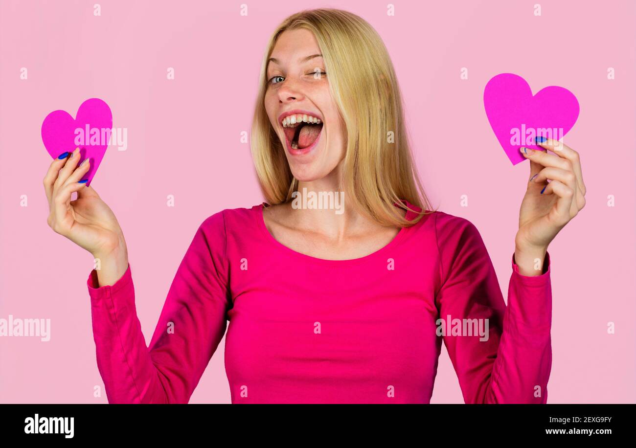 Valentinstag. Winkende Frau mit Papierherzen in den Händen. Glückliches Mädchen am Valentinstag mit Herz-Symbol. Stockfoto