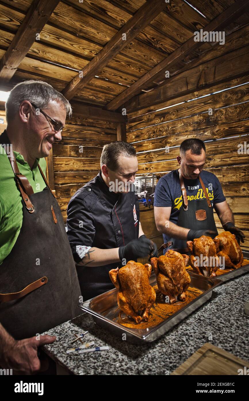 Kochkurs drei Mann Vorbereitung Huhn Stockfoto