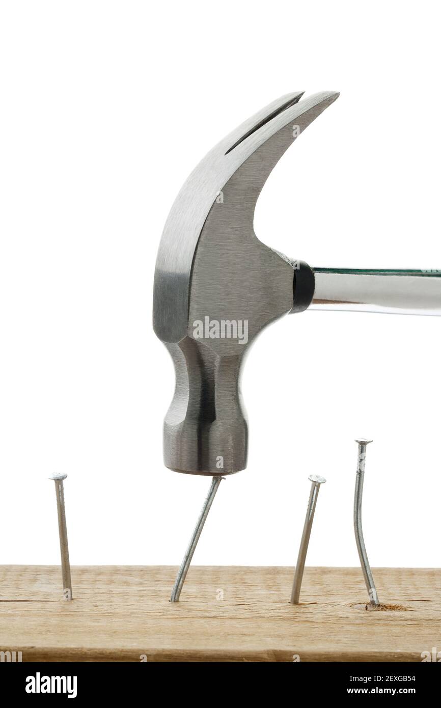 Hämmernde Nägel auf Holzbrett Stockfoto