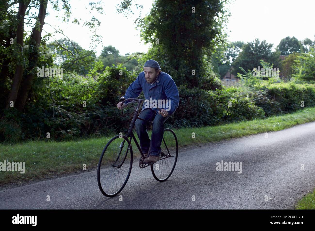 Mann Radfahren volle Geschwindigkeit auf Landstraße Stockfoto