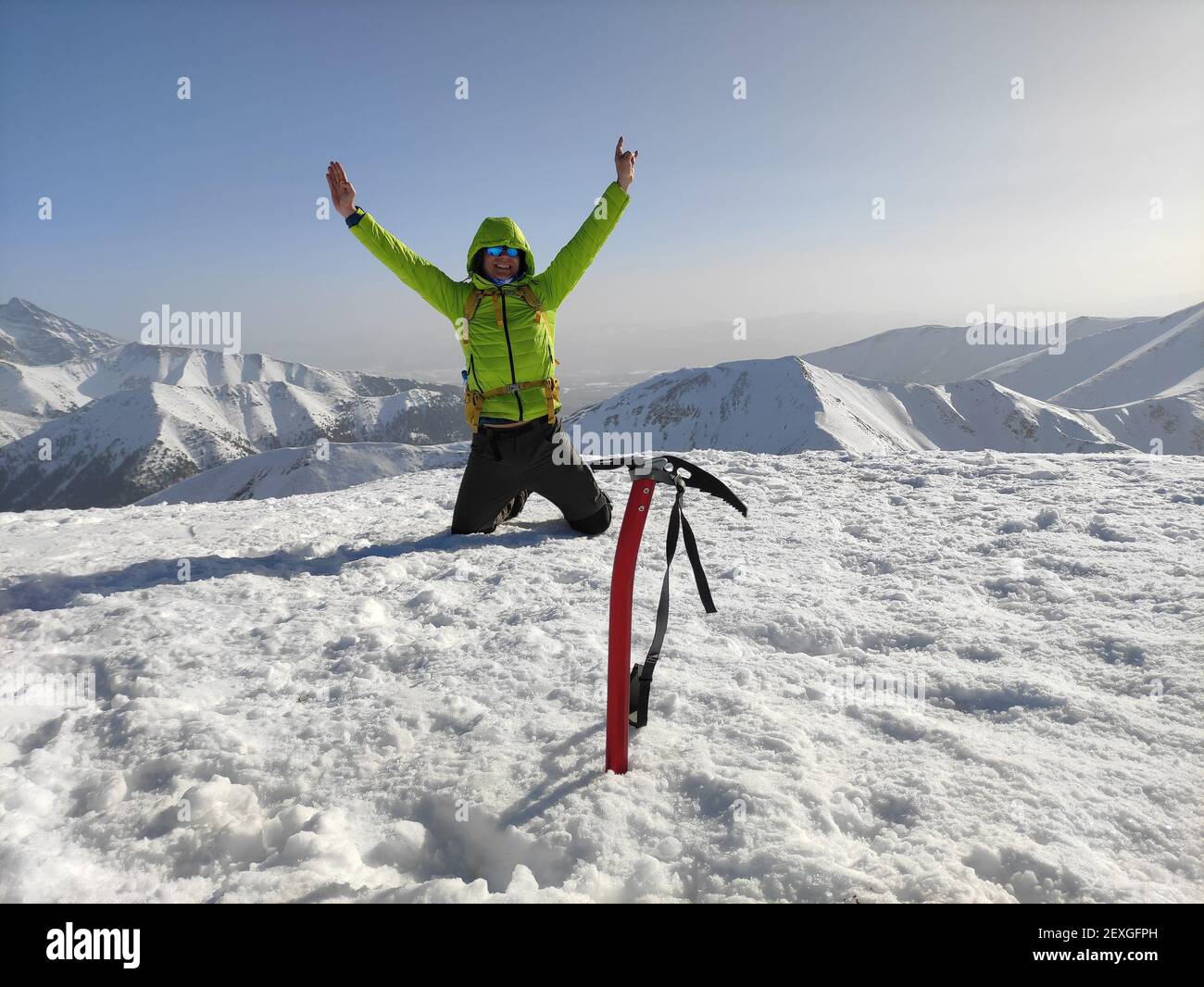 Wanderer, Kletterer auf einem Berg mit erhobenem Arm als Zeichen des Sieges. Stockfoto