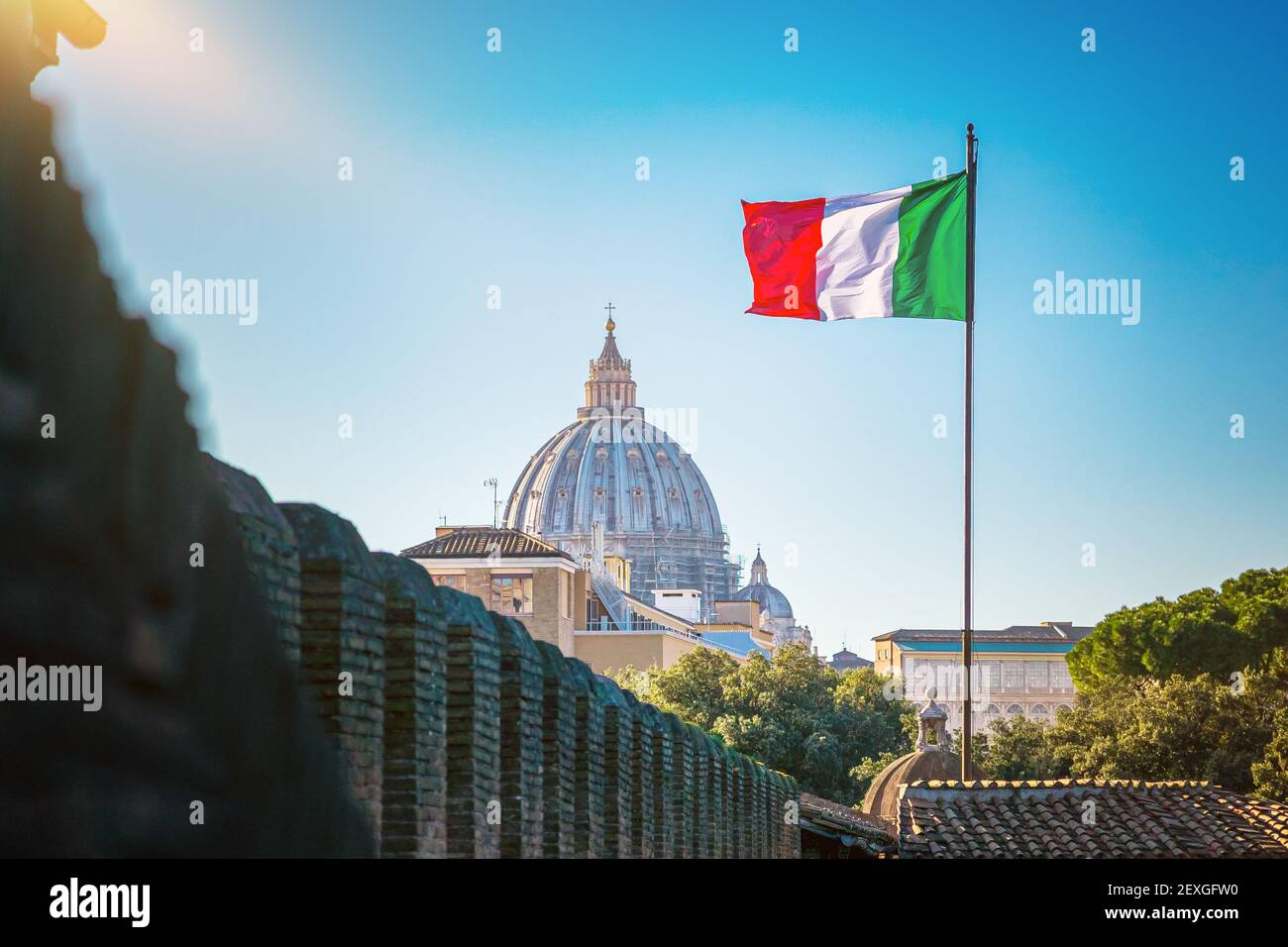 Blick auf die Petersbasilika im Vatikan und schwenkende italienische Flagge. Stockfoto
